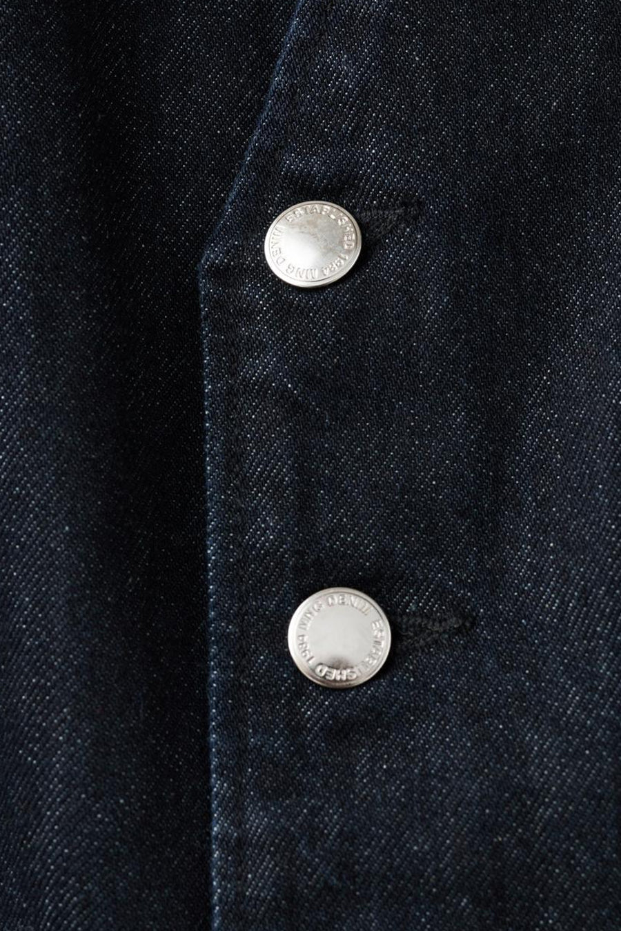 Blauwe denim overall van MANGO, met twee zilveren knopen, close-up.