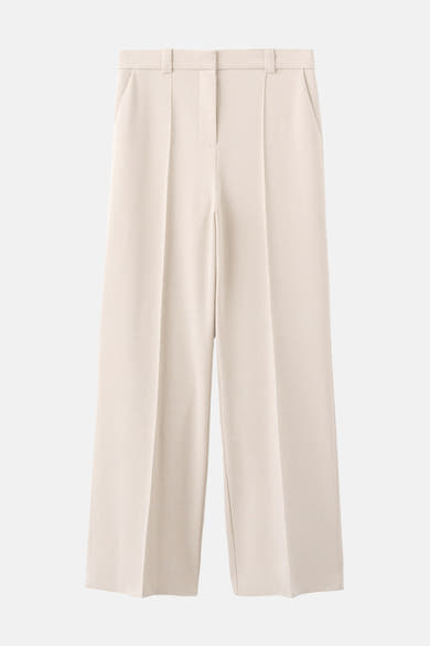 Pantalon beige de MANGO, coupe ample avec poches latérales et passants de ceinture.