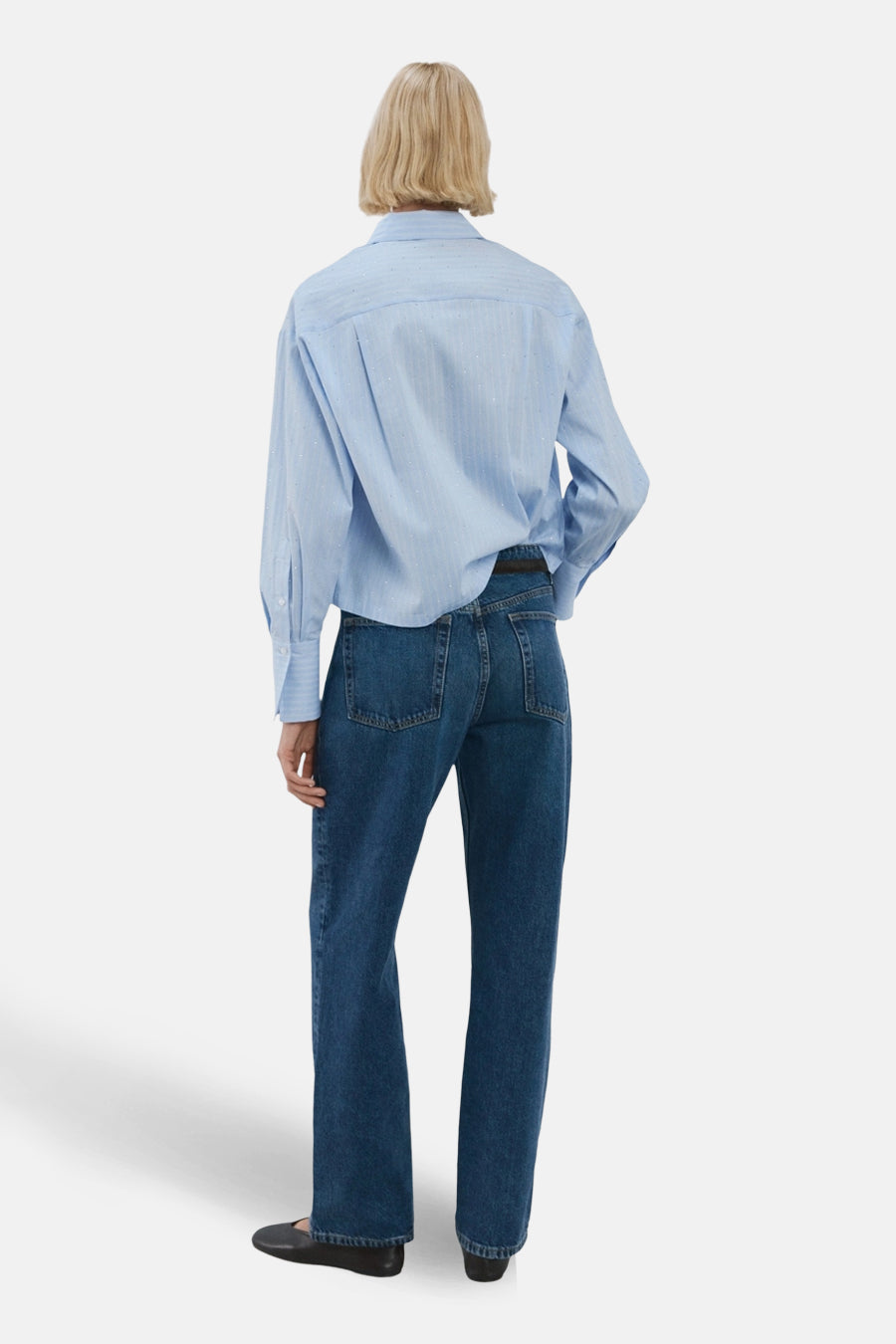 Chemise à manches longues bleue à rayures fines de MANGO, vue de dos, portée avec un jean brut et des chaussures plates noires.