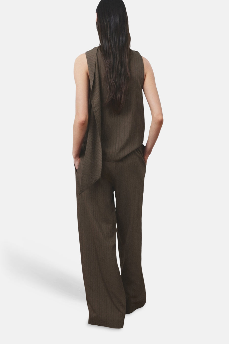 Pantalon brun de MANGO, coupe ample avec poches et texture subtilement rayée, porté avec un haut assorti.