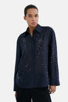 Marineblauwe blouse met lange mouwen van MANGO, versierd met kralen op de mouwen, van achteren gezien.