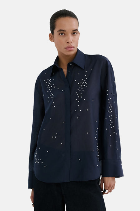 Chemise bleue à manches longues de MANGO, ornée de petits strass décoratifs sur le devant.
