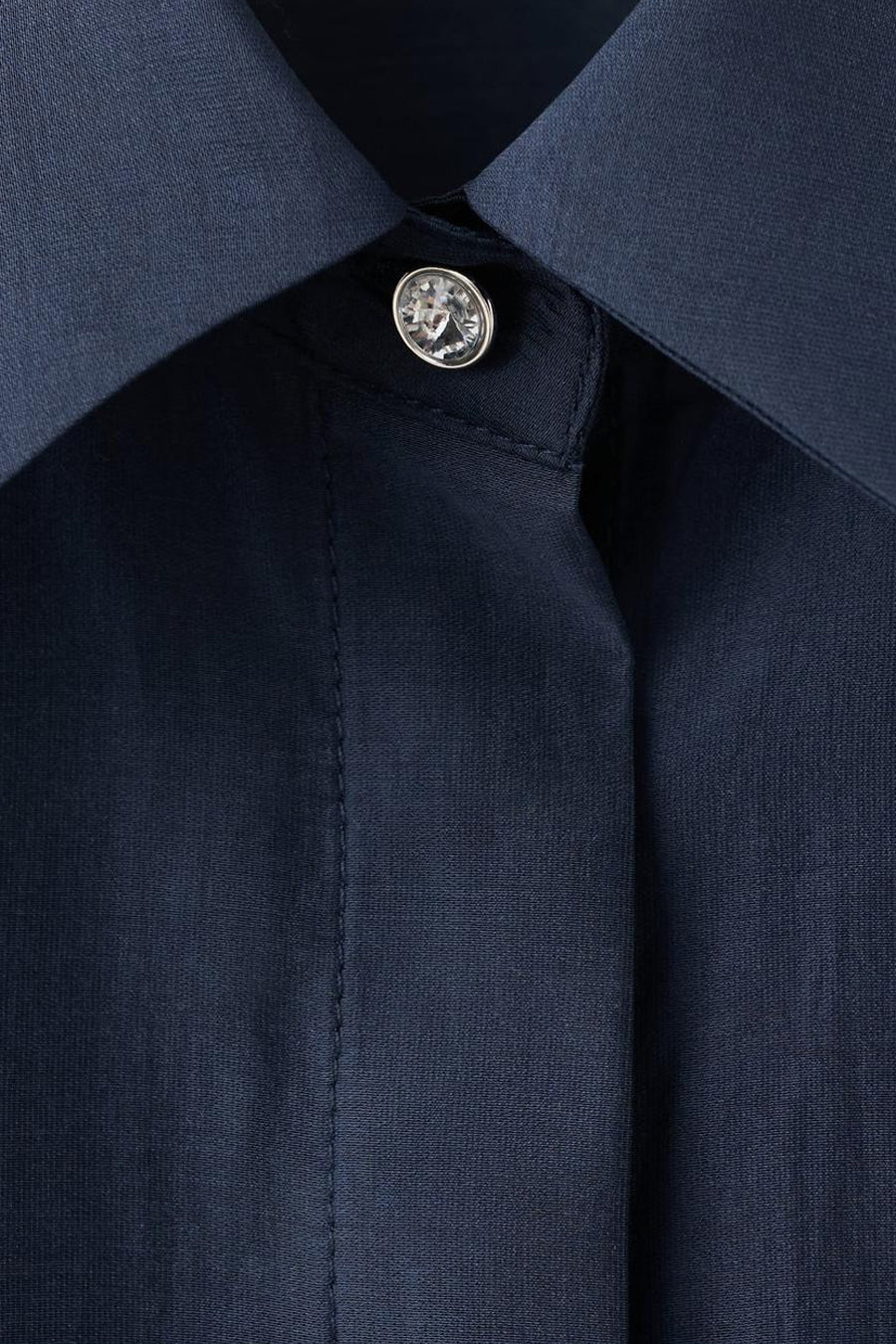 Blauwe blouse met lange mouwen van MANGO, met een sierlijke strass-knoop aan de kraag.