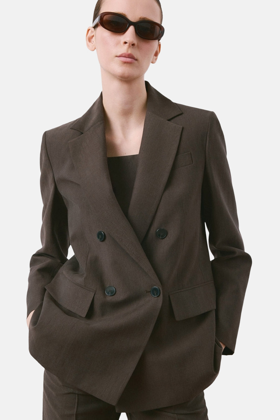 Bruine blazer van MANGO, achterzicht, gedragen met een bijpassende broek en een bruine handtas.