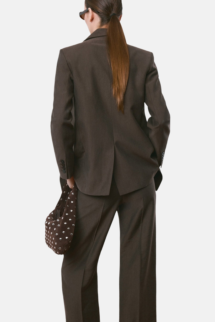 Blazer brun de MANGO, vue de dos, porté avec un pantalon assorti et un sac à main marron.