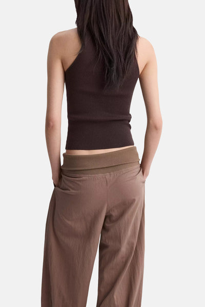 Top brun de MANGO, côtelé et sans manches, vu de dos avec un pantalon ample marron.
