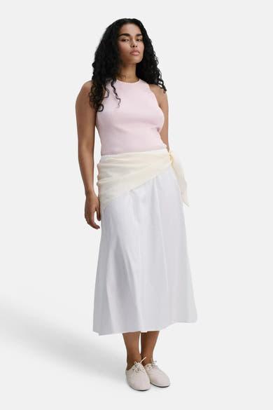 Roze geribbelde top zonder mouwen van MANGO, gedragen met een witte rok en een crèmekleurige sjaal.