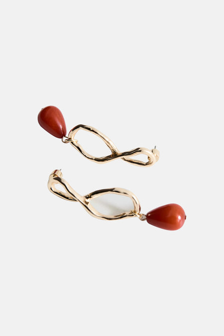 Gouden en terracotta oorbellen van MANGO met een golvend organisch ontwerp en druppelvormige kralen.
