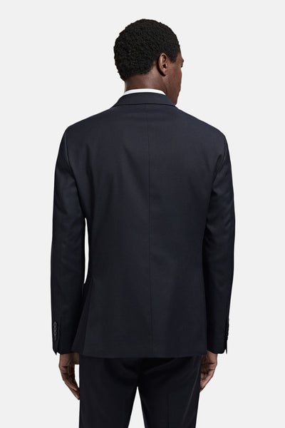 Blauwe blazer van MANGO, getailleerde pasvorm van achteren gezien, detail van mouwknopen.