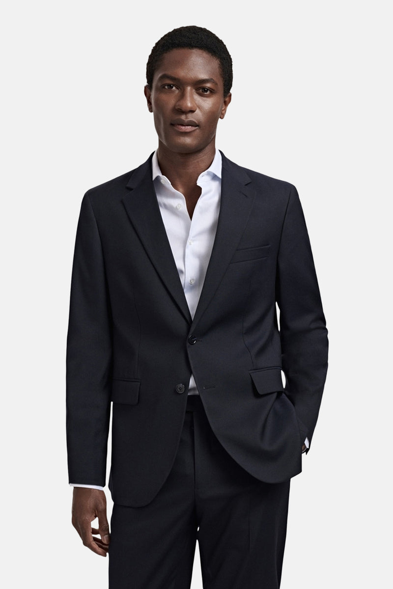 Blauwe blazer van MANGO gedragen met een licht overhemd, gepresenteerd op een paspop.