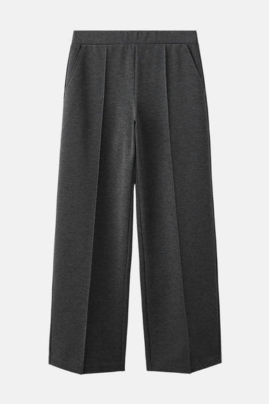 Pantalon gris de MANGO, coupe ample, avec des plis et des poches latérales.