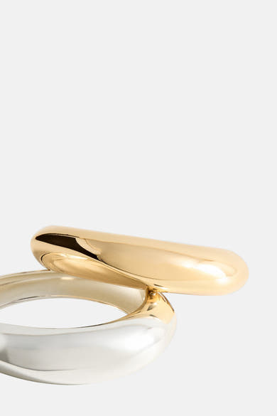 Bracelet doré par Mango, présentant deux joncs entrelacés en or et argent poli.
