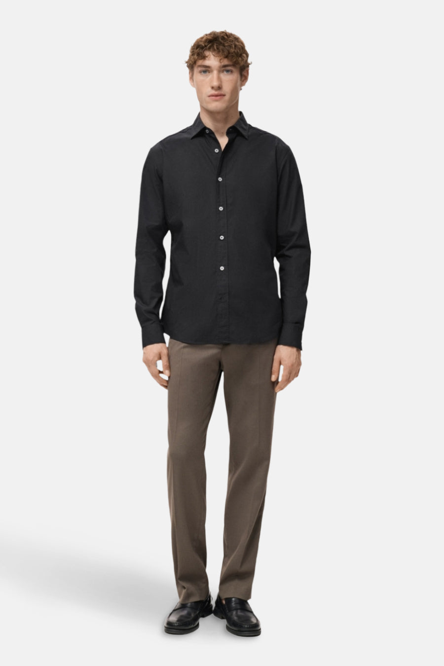 Zwart overhemd met lange mouwen van MANGO, gedragen met een bruine broek en zwarte leren schoenen.