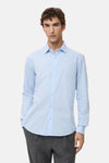 Blauwe blouse met lange mouwen van MANGO, van achteren gezien, gedragen met een donkergrijze broek.