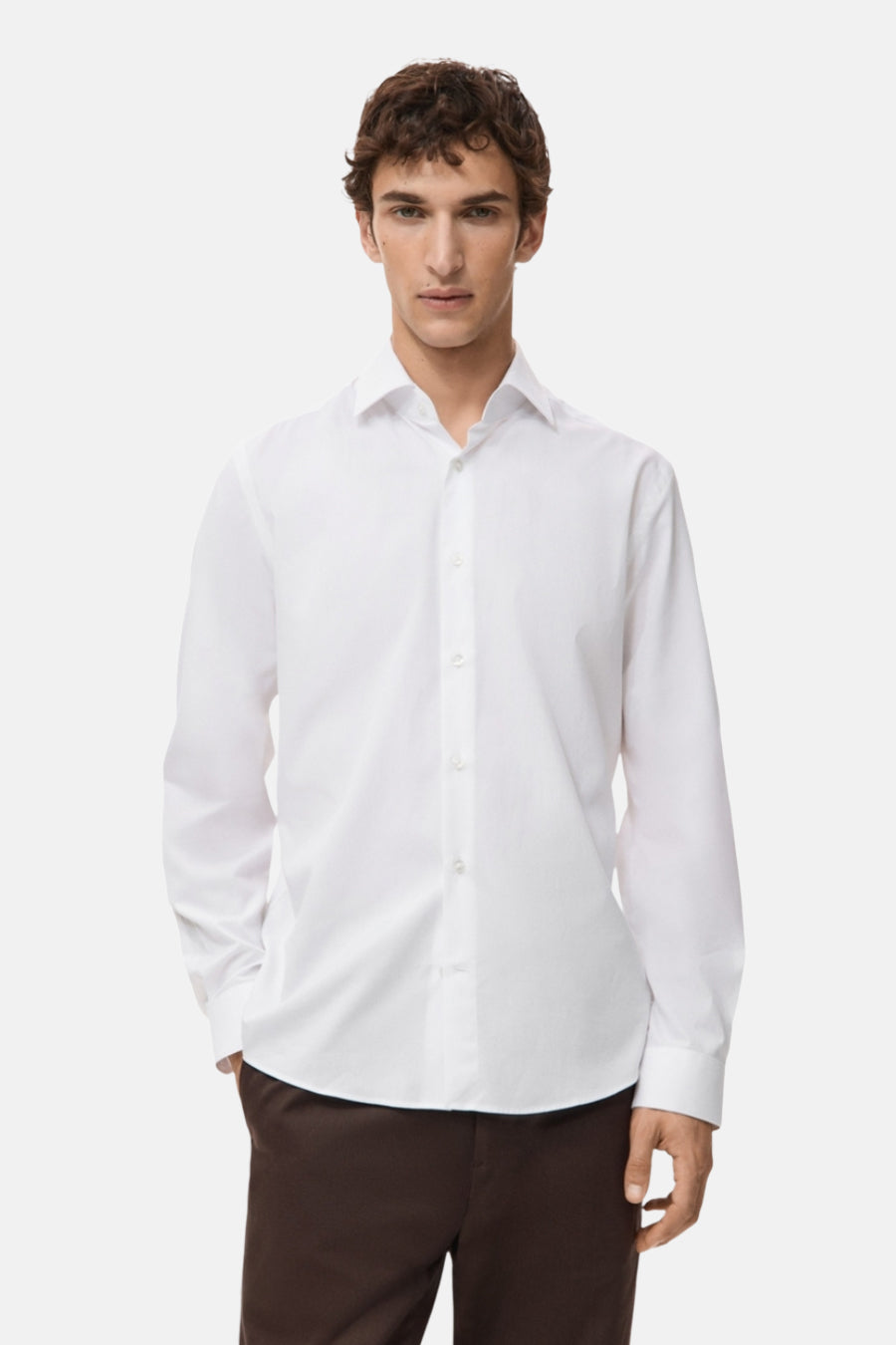 Wit overhemd met lange mouwen van MANGO, van achteren gezien, gedragen met een bruine broek.