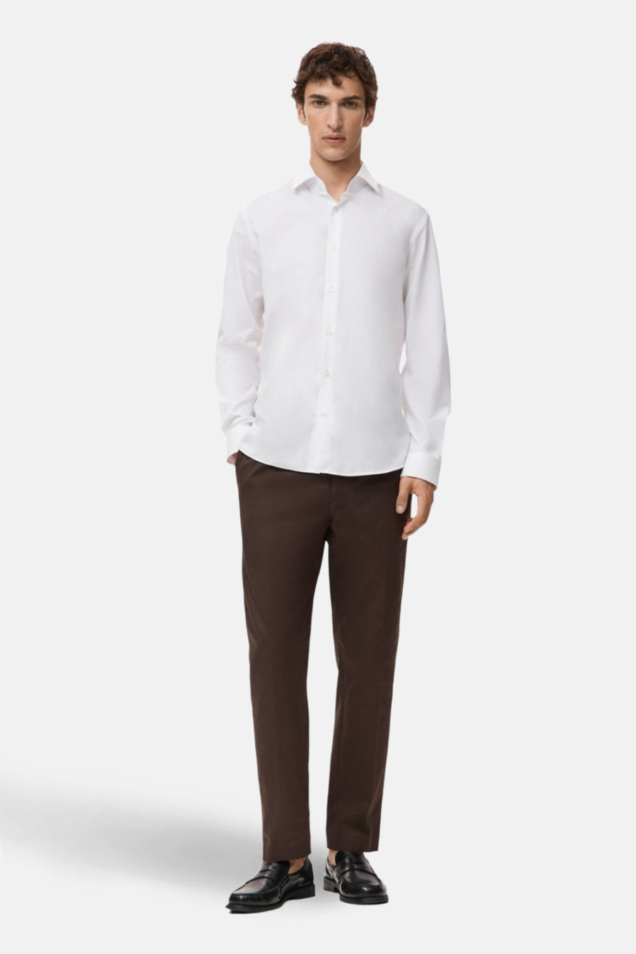 Wit overhemd met lange mouwen van MANGO, gedragen met een bruine broek en zwarte schoenen.