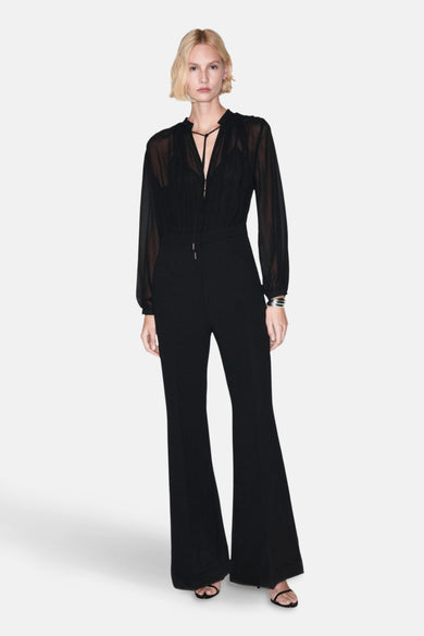 Zwarte jumpsuit van MANGO, met een doorschijnend bovenstuk met lange mouwen en een uitlopende broek.