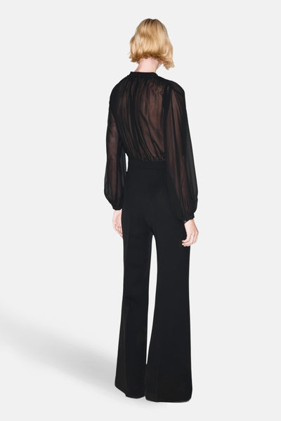 Zwarte jumpsuit van MANGO, met doorschijnend bovenstuk met lange mouwen en uitlopende broek met hoge taille.