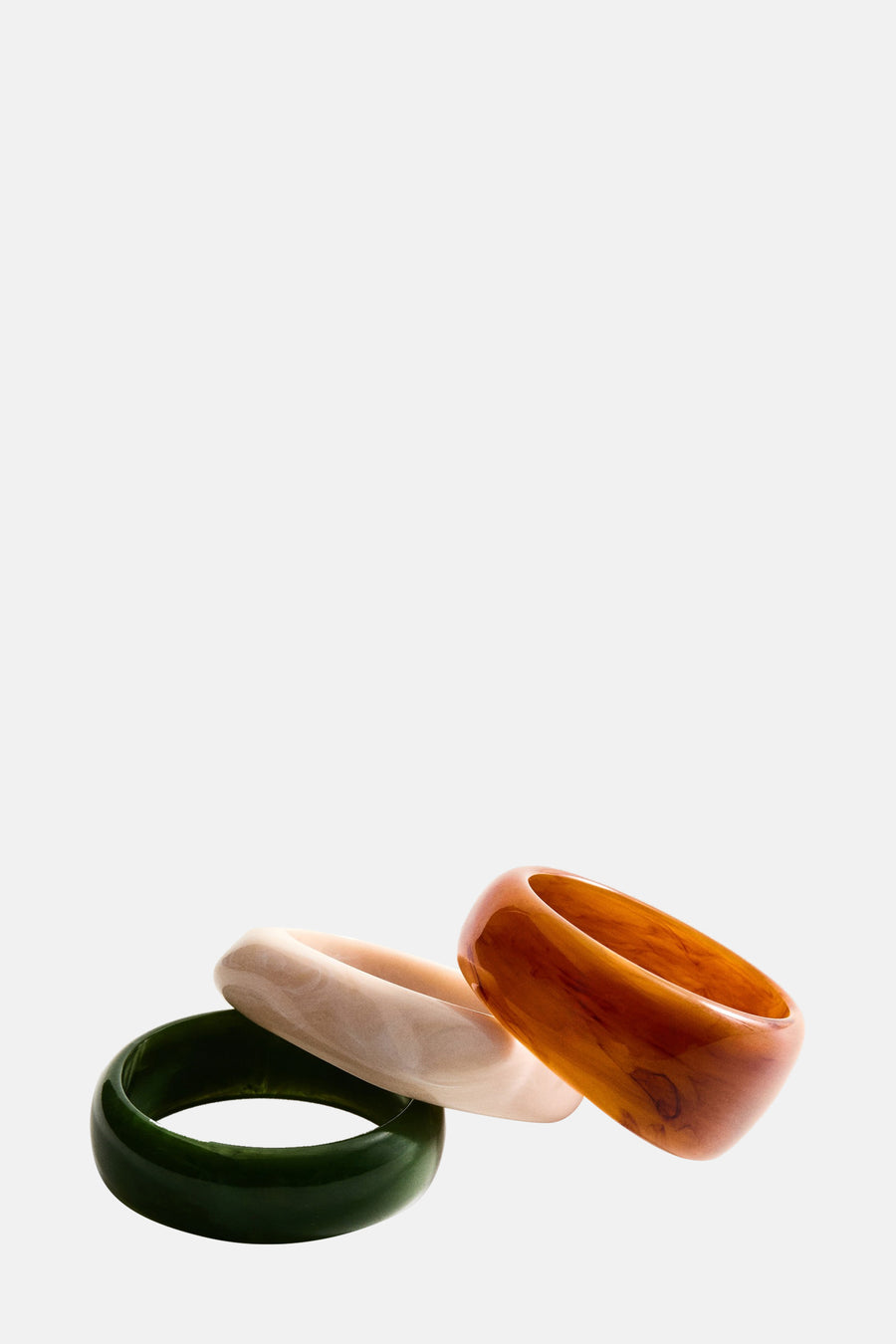 Bracelets multicolores par MANGO, trois pièces de différentes couleurs et textures, empilées.
