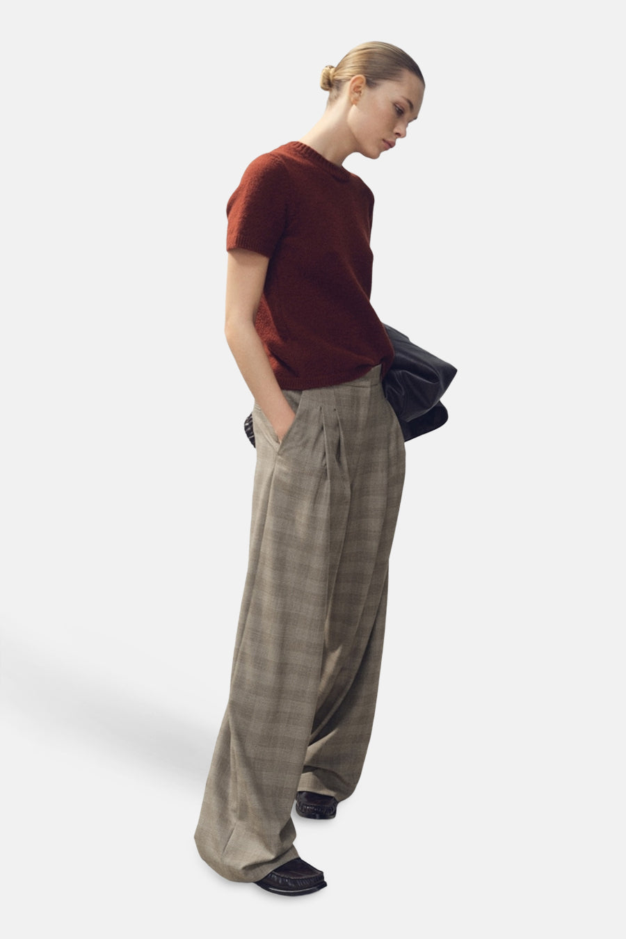 Pull à col rond brun de MANGO, porté avec un pantalon ample à carreaux et des mocassins.