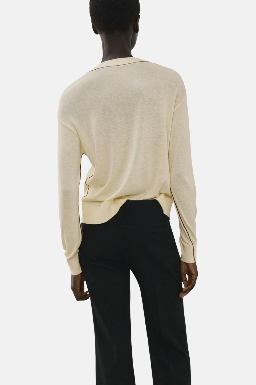 Pull à col en V jaune de MANGO, avec une bordure contrastante le long de l'encolure et des manches.
