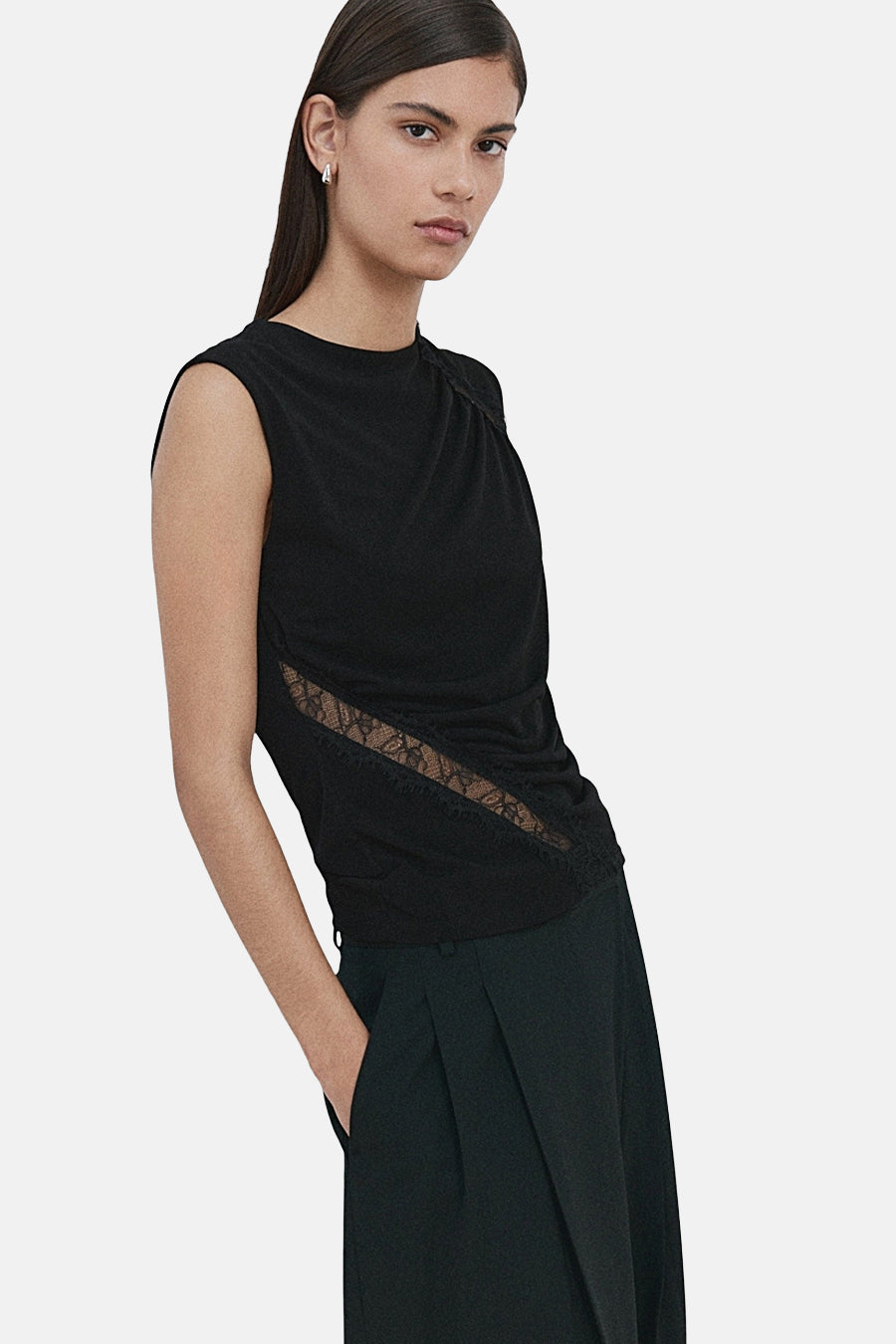 Blouse noire sans manches de MANGO, avec empiècement en dentelle sur le côté.