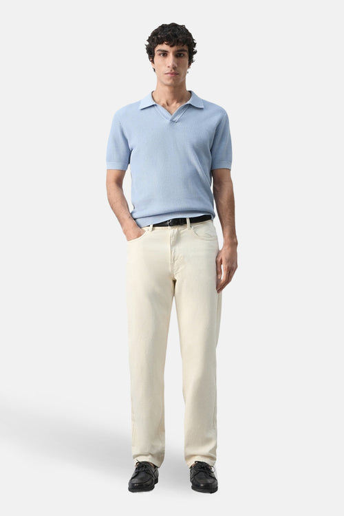 Polo à manches courtes bleu de MANGO, porté avec un pantalon beige et des chaussures noires.