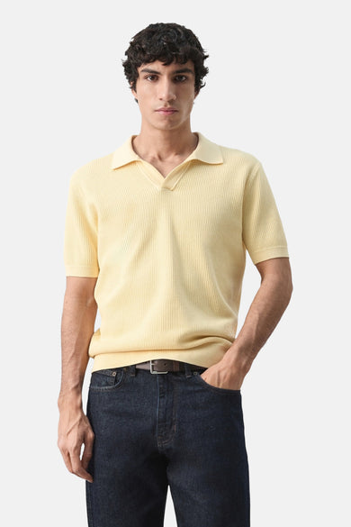 Gele polo met korte mouwen van MANGO, gedragen met een spijkerbroek, achtergezicht.