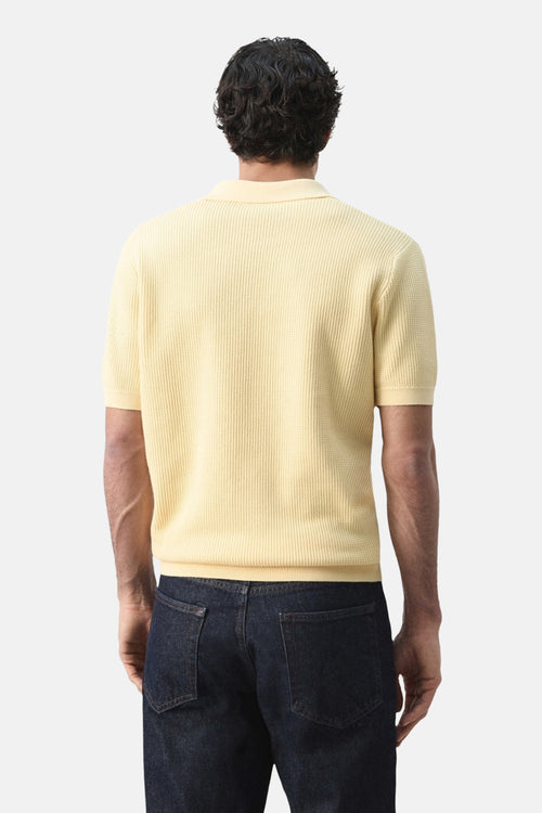Polo jaune à manches courtes de MANGO, porté avec un jean, vue de dos.
