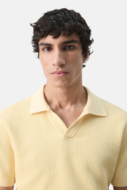 Polo à manches courtes jaune de MANGO, en maille texturée avec un col ouvert.