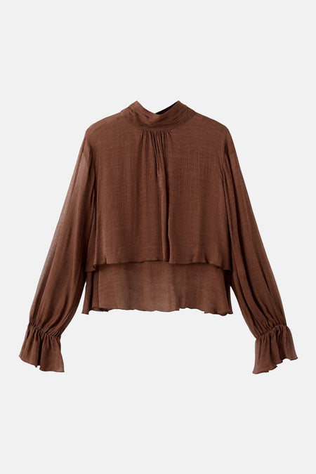 Chemisier brun à manches longues par MANGO, avec col montant, coupe ample et détails plissés aux poignets.
