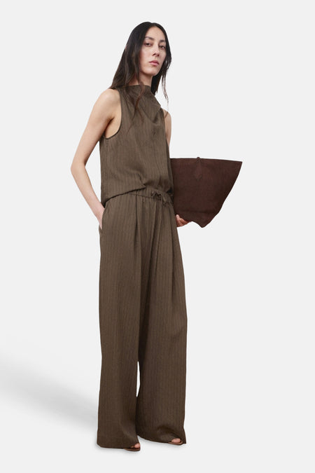 Blouse sans manches brun de MANGO, avec un pantalon large assorti et un grand sac à main.