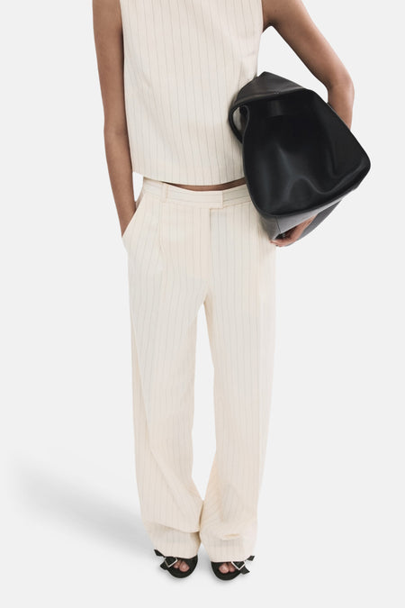 Pantalon rayé blanc de MANGO, à jambes larges, porté avec un haut court rayé et des sandales noires.