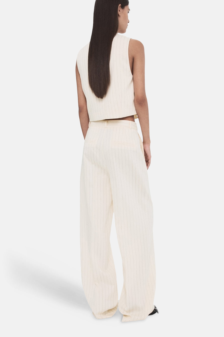 Pantalon blanc de MANGO, coupe ample, rayé verticalement, porté avec un haut assorti.