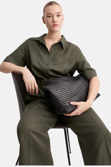 Bruin jumpsuit van MANGO, gedragen door een model dat op een stoel zit.