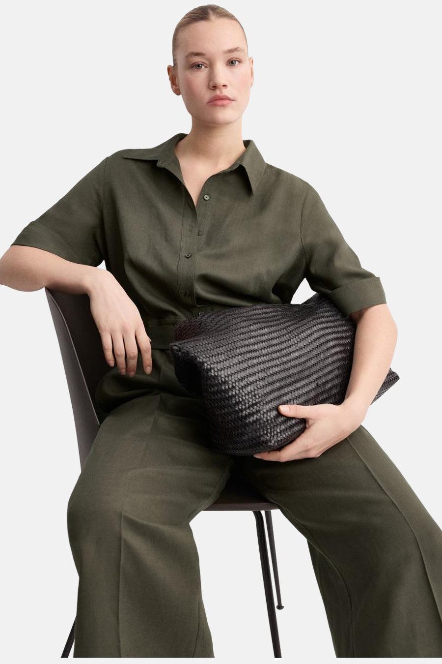 Bruin jumpsuit van MANGO, gedragen door een model dat op een stoel zit.