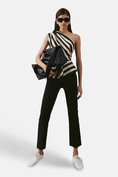 Blouse sans manches multicolore de MANGO, rayures verticales et pantalon noir, tenue complétée par des lunettes de soleil.
