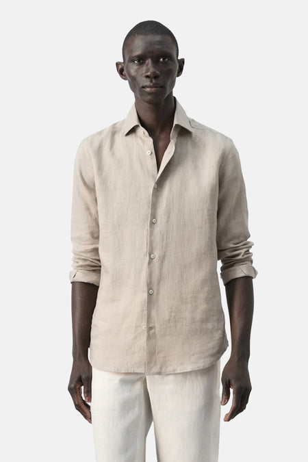 Chemise beige à manches longues de MANGO, en lin, avec une coupe droite et un col classique.