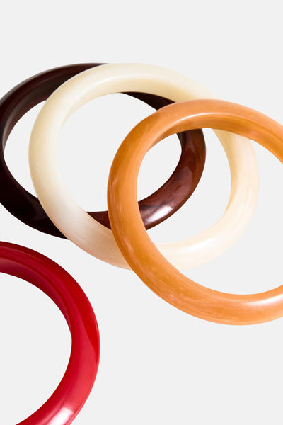 Bracelets multicolores de MANGO, ensemble de quatre pièces, tons unis rouge, marron, beige et orange.