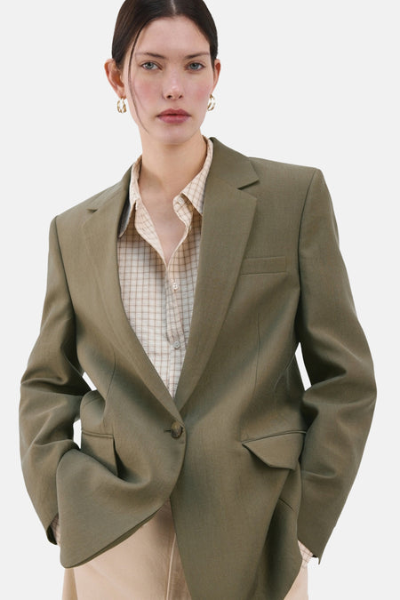 Kaki blazer van MANGO, achterzijde, met inkepingen en een split achter.