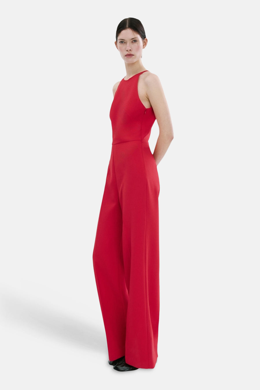 Rode jumpsuit van MANGO, halternek met striksluiting, wijde pijpen, achterzicht.