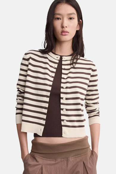 Crèmekleurig en bruin gestreept kort vest van MANGO, open gedragen over een bruine top en broek.