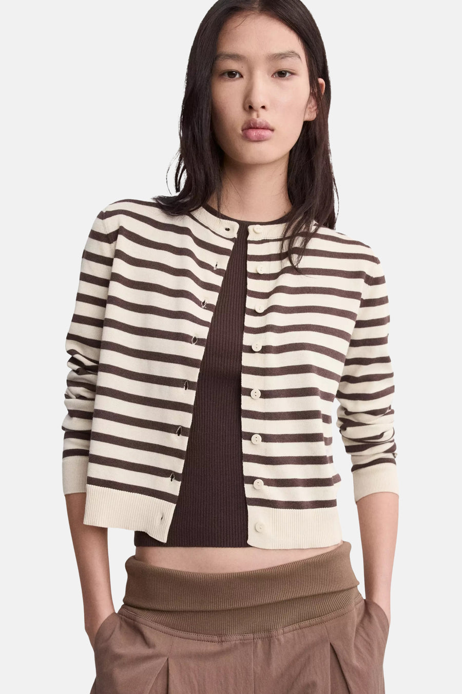 Crèmekleurig en bruin gestreept kort vest van MANGO, open gedragen over een bruine top en broek.