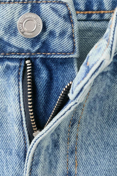 Rechte spijkerbroek van lichtblauw denim van MANGO, met een gedeeltelijk geopende ritssluiting en een zilverkleurige knoopsluiting.
