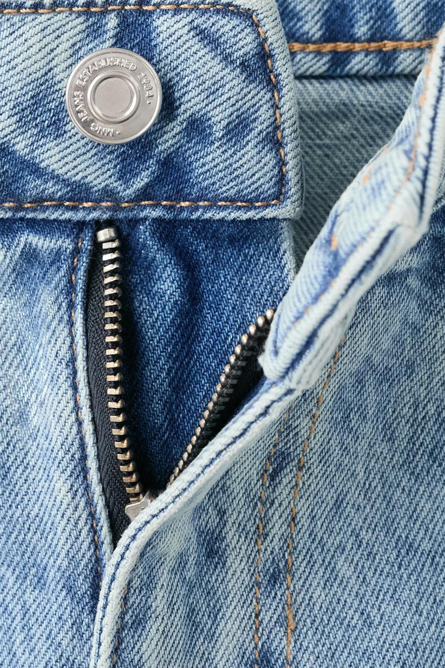 Rechte spijkerbroek van lichtblauw denim van MANGO, met een gedeeltelijk geopende ritssluiting en een zilverkleurige knoopsluiting.