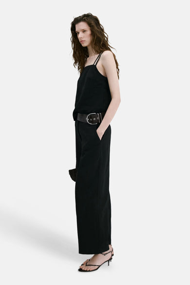 Pantalon noir de MANGO à jambe large, avec une large ceinture noire à boucle argentée.