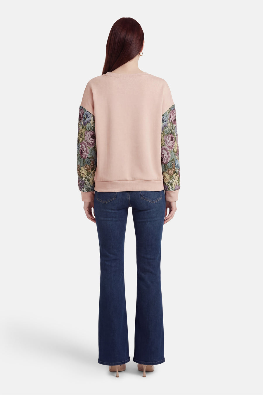 Sweat-shirt beige col rond de Terra di Siena, avec manches à motif floral, porté avec un jean bleu.