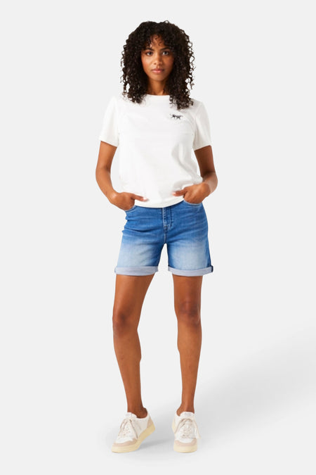 Bermuda bleu denim moyen de GARCIA, porté avec un t-shirt blanc et des chaussures de sport.