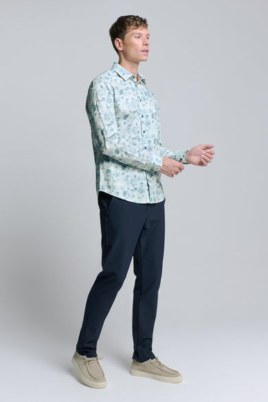 Chemise à manches longues bleue de NO EXCESS, à motifs floraux, portée avec un pantalon bleu marine et des chaussures décontractées beige.