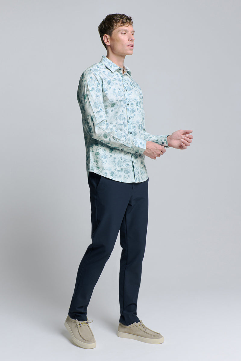 Chemise à manches longues bleue de NO EXCESS, à motifs floraux, portée avec un pantalon bleu marine et des chaussures décontractées beige.